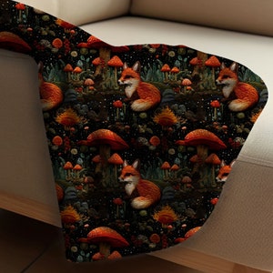 May include: A black fabric with a repeating pattern of orange foxes sitting amongst red and orange mushrooms on a dark green background.