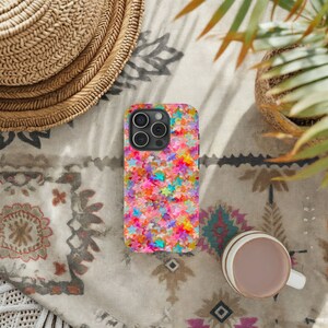 May include: A colorful phone case with a pattern of pink, blue, green, yellow, and orange stars. The case is designed for a phone with a camera bump.