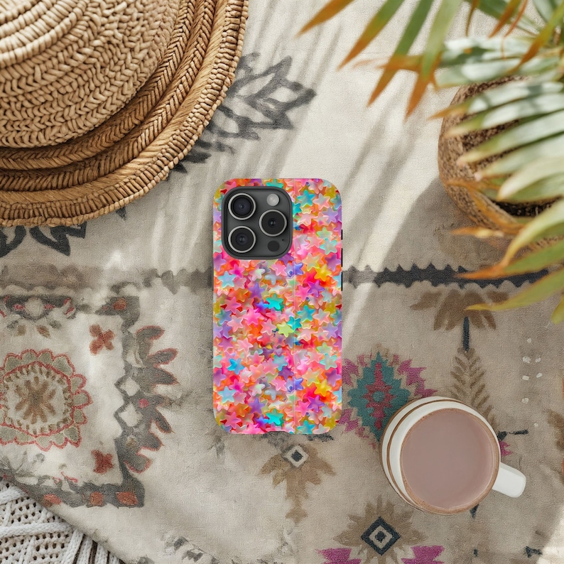 May include: A colorful phone case with a pattern of pink, blue, green, yellow, and orange stars. The case is designed for a phone with a camera bump.