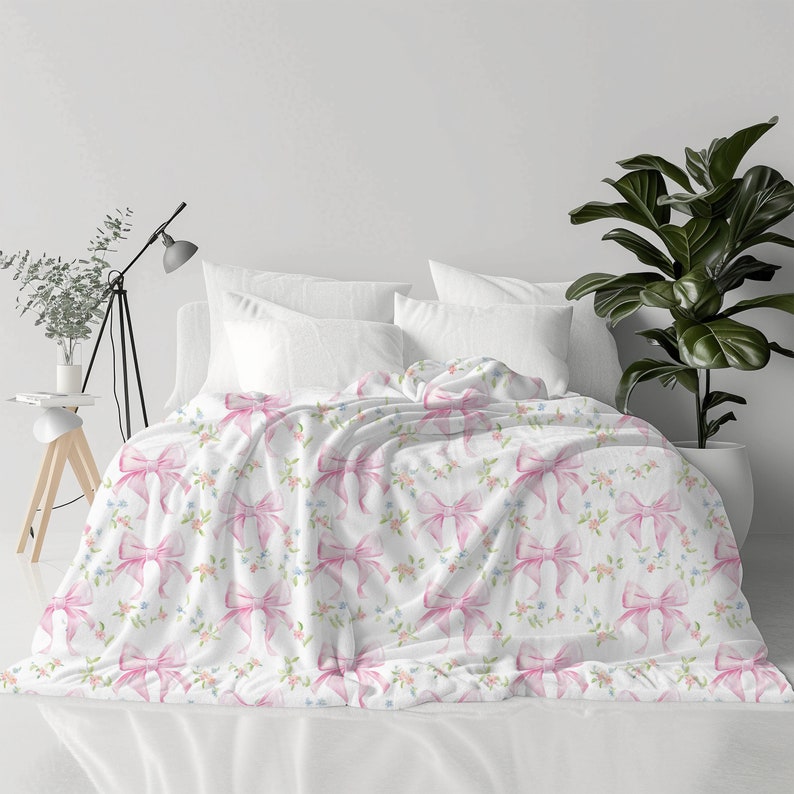 May include: White bedding with a pink bow and floral pattern.