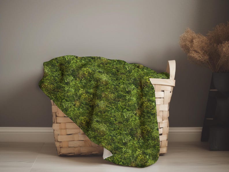 May include: A woven wicker basket with a green moss-like fabric draped over the top. The basket is sitting on a light gray floor.