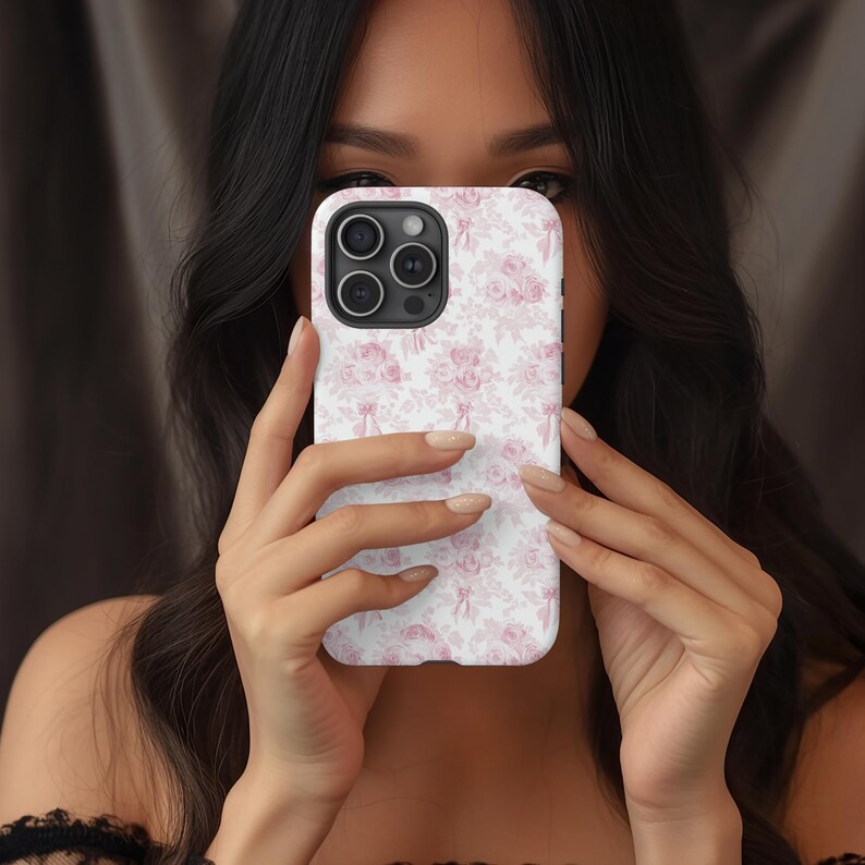 Op de afbeelding: Een witte iPhone-hoes met een roze bloemenpatroon. De hoes heeft een uitsparing voor de camera.
