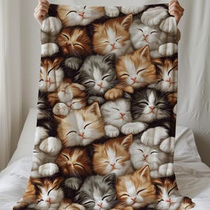 May include: A colorful blanket featuring a pattern of sleeping cats with brown, white, gray, and orange fur. The cats are arranged in a pile, with their faces and paws visible.