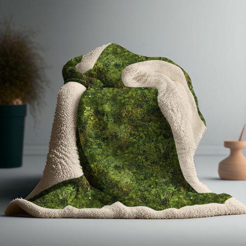 May include: A soft, plush throw blanket with a green moss pattern on one side and a white sherpa fleece on the other side.
