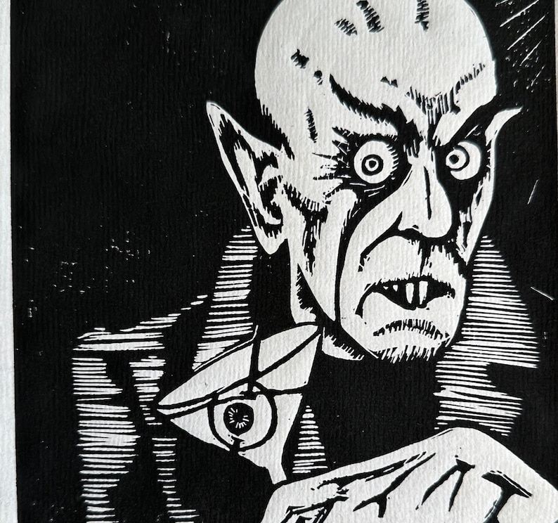 Schwarz/Weiss Linoldruck. Motiv: Nosferatu mit einem Glas Martiniin der Hand. Nosferatu trinkt diesen natürlich mit einem aufgespiessten Augapfel, anstelle einer klassischen Olive :). Der Druck ist handgezeichnet, handgedruckt und signiert.