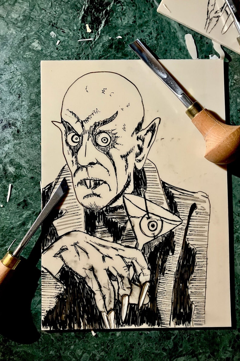Schwarz/Weiss Linoldruck. Motiv: Nosferatu mit einem Glas Martiniin der Hand. Nosferatu trinkt diesen natürlich mit einem aufgespiessten Augapfel, anstelle einer klassischen Olive :). Der Druck ist handgezeichnet, handgedruckt und signiert.