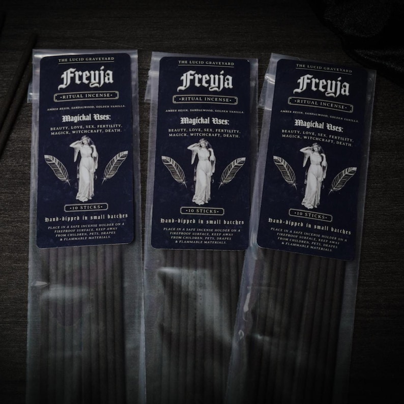 May include: Three packages of Freyja Ritual Incense. Each package has a dark blue label with white text and a drawing of a woman. The text includes "Magichal Uses: Beauty, Love, Sex, Fertility, Magick, Witchcraft, Death."