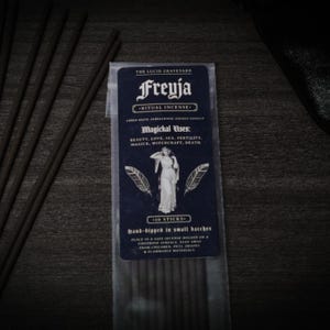 May include: A package of Freyja ritual incense with the text "The Lucid Graveyard". The dark blue label features a woman illustration and the text "Magichal Uses: Beauty, Love, Sex, Fertility, Magick, Witchcraft, Death." Ten incense sticks are visible.