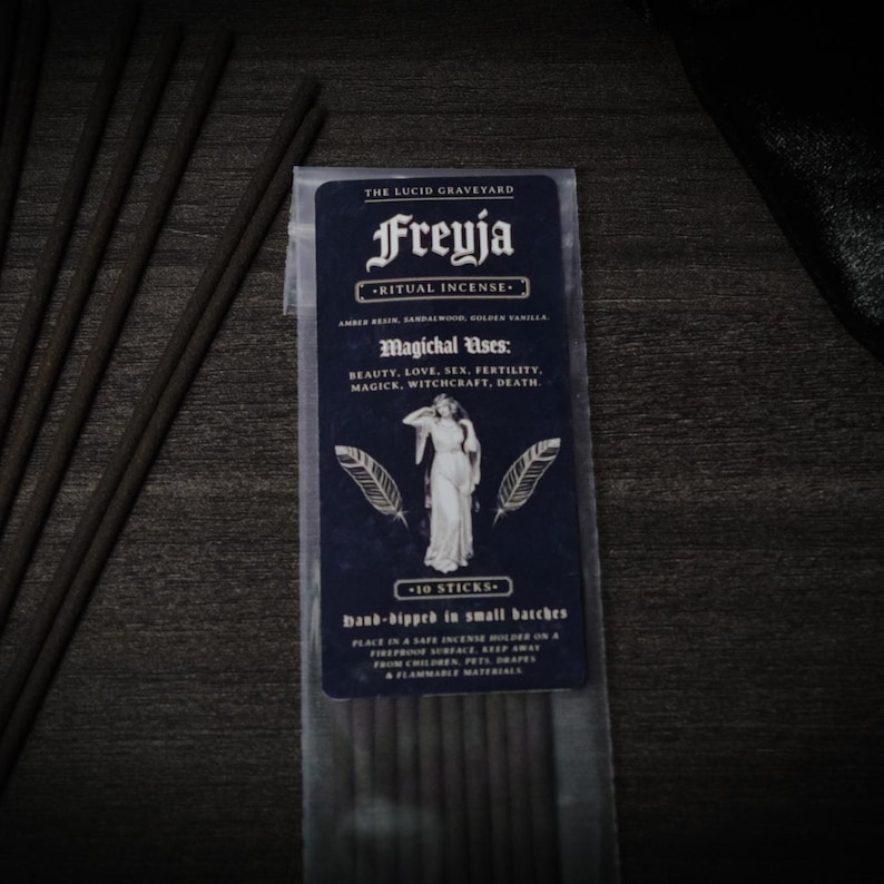 May include: A package of Freyja ritual incense with the text "The Lucid Graveyard". The dark blue label features a woman illustration and the text "Magichal Uses: Beauty, Love, Sex, Fertility, Magick, Witchcraft, Death." Ten incense sticks are visible.