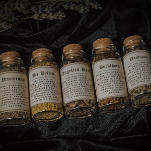 May include: Six small glass bottles with cork tops, each filled with dried herbs and labeled with the name of the herb and its magical properties. The labels are in a vintage style font and include descriptions of the herbs' uses in spells and rituals.