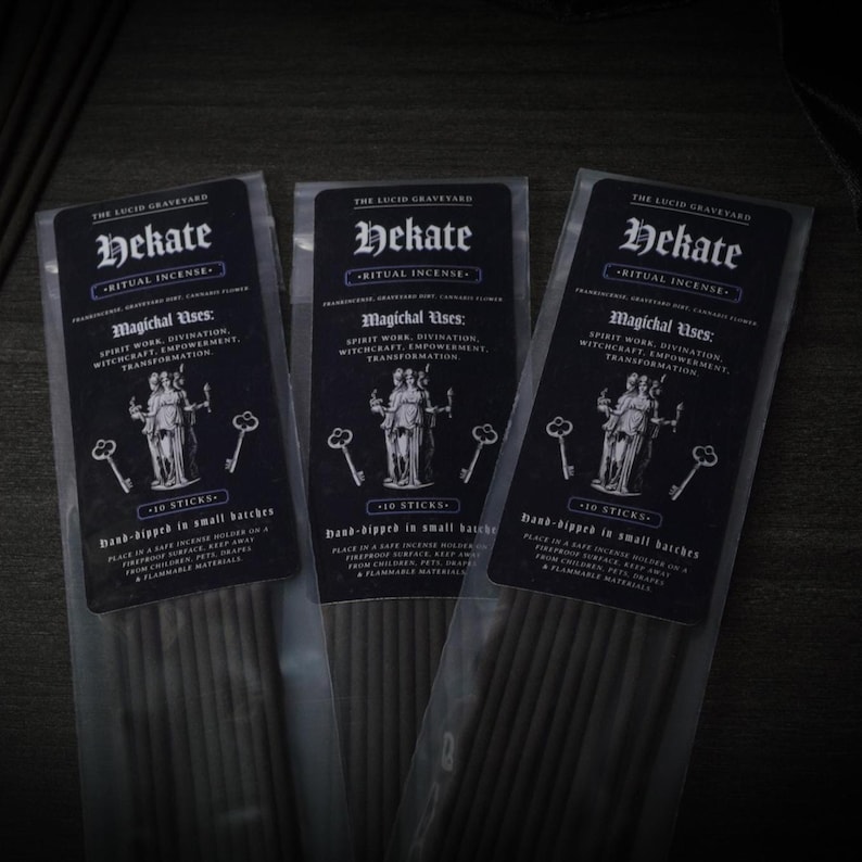 May include: Three packages of Hekate ritual incense. Each package has a black label with white text, including "Hekate" and "Magichal Uses." The labels feature an illustration of a goddess and keys. Each package contains 10 sticks.