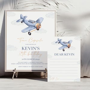 May include: A blue and white time capsule sign with a watercolor illustration of a blue airplane. The sign says "Time Capsule" and "Kevin's 18th Birthday" with the date "10th March 2042". There is a separate white card with the words "Dear Kevin" and lines for writing.