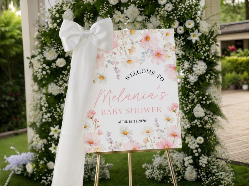 Set of printable baby shower kit featuring invitations, envelopes, and tags in soft pink with hand-drawn cosmos wildflowers, elegant gold script, and green foliage accents on a light blush background.