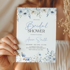 Puede incluir: Una invitaci&oacute;n de ducha nupcial blanca con flores azules de acuarela y el texto "Join us for a Bridal Shower in honor of the bride Anna Smith. S&aacute;bado, 15 de diciembre a las 3 PM. Le Grand Floral Cafe, 81 Floral Street, San Francisco. RSVP: Sofia 123-456-7890."