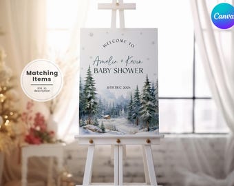 May include: A white easel displays a baby shower sign with a winter landscape illustration. The sign reads "Welcome to Amelia + Kevin BABY SHOWER 18th DEC 2024." The sign has a Canva logo in the upper right corner. A "Matching Items" graphic is in the upper left.