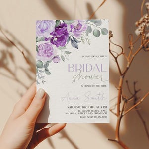 May include: A purple and green floral bridal shower invitation with the text "PLEASE JOIN US FOR A BRIDAL SHOWER IN HONOR OF THE BRIDE Anna Smith SATURDAY, DEC 13TH AT 3 PM LE GRAND FLORAL CAFE 81 FLORAL STREET, SAN FRANCISCO RSVP SOFIA 123-456-7890"