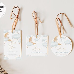 Può includere: Tre etichette per bomboniere di baby shower bianche con nuvole acquerellate blu, stelle dorate e una luna crescente. Le etichette sono legate con uno spago marrone e hanno il testo "Grazie", "Baby Shower di Lana" e "Baby Shower di Lana".