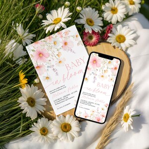 A baby shower stationery bundle showcasing watercolor pink cosmos and wildflower accents on a soft cream backdrop, with coordinating invitation, RSVP card, signage, and banner, featuring delicate script typography and botanical illustration style, fully editable in Canva.