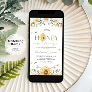 May include: A baby shower invitation with a watercolor design of sunflowers, bees, and honeycomb. The text reads "A Little Honey is on the way".