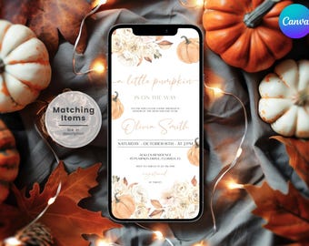 May include: A smartphone displays a baby shower invitation with the text "a little pumpkin is on the way." The design features watercolor pumpkins and floral elements. The background includes pumpkins, fall leaves, and string lights.