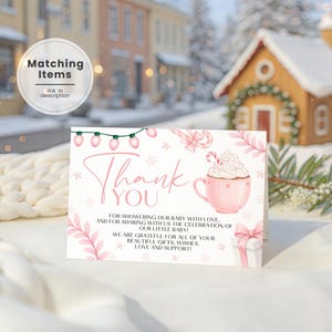 Może przedstawiać: Karta z podziękowaniami na baby shower z różowym i białym wzorem. Karta zawiera słowa "Dziękuję" w czcionce skryptowej, różowy kubek z bitą śmietaną i pudełko na prezent. Karta zawiera również tekst o baby shower.