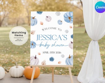 Puede incluir: Un letrero de bienvenida para baby shower sobre un caballete de madera, con calabazas de acuarela y detalles florales en azul, blanco y melocotón. El letrero dice "Bienvenida a la baby shower de Jessica, 13 de abril de 2026."