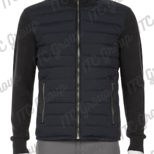 Puede incluir: Chaqueta acolchada azul marino con cremallera completa y dos bolsillos laterales. La chaqueta tiene mangas de punto gris oscuro y un cuello a juego. La chaqueta se exhibe en un maniquí.