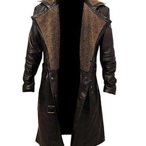 May include: A long, black leather coat with a brown, faux fur-lined collar. The coat has a double-breasted design, a belt at the waist, and button closures. A classic outerwear garment.