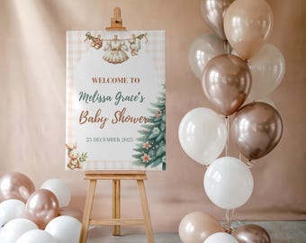 May include: A baby shower sign on a wooden easel, with the text "Welcome to Melissa Grace's Baby Shower" and the date December 25, 2023. The sign is decorated with a baby clothes and a Christmas tree design. Balloons in white, gold, and brown surround the sign.