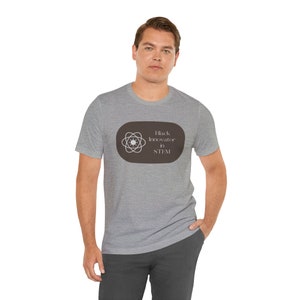 May include: A heather grey t-shirt with a brown oval graphic featuring a stylized atom and the text "Black Innovator in STEM!"