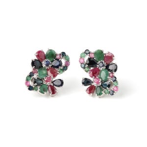 May include: A pair of silver earrings with a cluster of colorful gemstones. The earrings feature a mix of emerald green, ruby red, sapphire blue, and pink gemstones. The gemstones are arranged in a floral design.