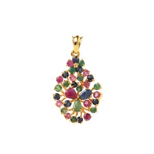 Puede incluir: Un colgante dorado con un racimo de gemas coloridas. El colgante presenta una variedad de piedras en tonos rojos, verdes, azules y rosas. Las gemas están dispuestas en un diseño floral o abstracto.