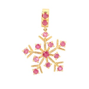 Peut inclure: Un pendentif en forme de flocon de neige doré avec des pierres précieuses roses. Le pendentif a une boucle en haut pour une chaîne. Le motif flocon de neige comporte une pierre précieuse centrale et de plus petites pierres précieuses le long des bras.