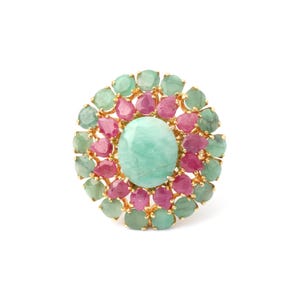 May include: A gold-toned ring featuring a large, oval, light-green gemstone at the center, surrounded by alternating pink and green gemstones. The ring has a floral design, with the gemstones set closely together.