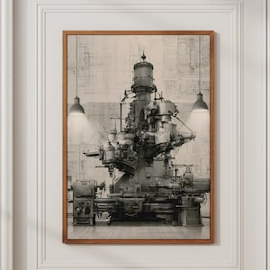 May include: A framed wall art print featuring a black and white illustration of a complex industrial machine. The machinery is centred, with two pendant lights hanging above it. The background displays a faint, grid-like technical blueprint pattern.