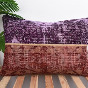 May include: Rectangular decorative pillow with a two-tone design. The top half is a deep purple, and the bottom half is a reddish-brown. A thin tan band separates the two colors. The pillow is placed on a wooden surface.