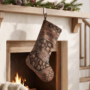May include: A Christmas stocking featuring a detailed, multi-colored woven pattern in shades of dark brown, muted orange, and cream. The fabric displays an intricate geometric and floral design reminiscent of a traditional rug, with a loop for hanging.
