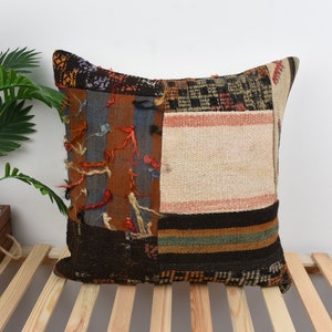 Può includere: Una federa patchwork con una varietà di colori e trame, tra cui marrone, nero, blu e bianco. La federa è realizzata con materiali riciclati e ha un aspetto unico e fatto a mano.