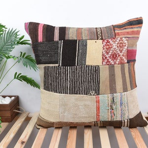 Puede incluir: Una funda de cojín de patchwork con una variedad de colores y patrones, incluyendo marrón, beige, rojo y azul. La funda de cojín está hecha de materiales reciclados y tiene un estilo rústico y bohemio.