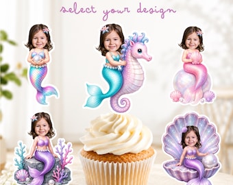 May include: Personalized cupcake toppers featuring a child's face on various mermaid illustrations. Designs include a mermaid holding a pearl, riding a seahorse, sitting on a sphere, resting on a rock with coral, and sitting inside a large seashell.