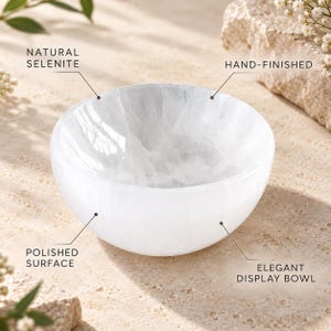 May include: A white, round bowl made of natural selenite with a polished surface. The bowl is hand-finished and serves as a display bowl. Text labels on the image identify the object as natural selenite, hand-finished, polished surface, and display bowl.