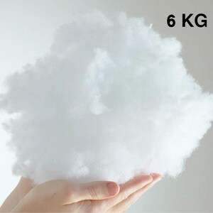May include: A large, fluffy, white cloud of polyester fiberfill, weighing 6 kg. The fiberfill is held in a person's hands.