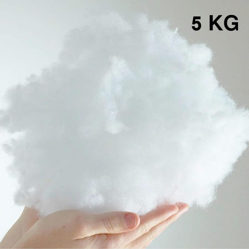 May include: A large, fluffy, white cloud of polyester fiberfill, held in a person's hand. The fiberfill is 5 kg.