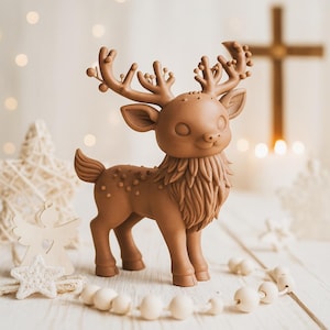 Op de afbeelding: Een bruin rendierbeeldje met gedetailleerd gewei en een pluizige borst. Het rendier staat op een wit houten oppervlak, met een snoer van witte kralen en decoratieve sterren op de achtergrond. Een feestelijke kerstversiering.