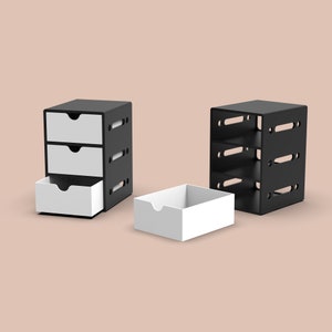 Puede incluir: Dos organizadores de almacenamiento negros con cajones blancos. Un organizador tiene tres cajones y el otro tiene tres estantes.