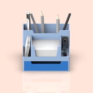 May include: A light blue desk organizer with a drawer and compartments for pens, pencils, and paper. The organizer has a blue drawer and a white compartment for paper.