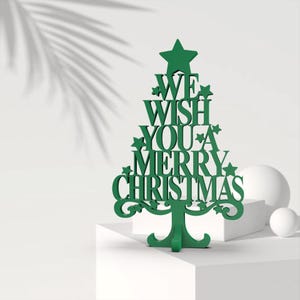May include: Green wooden Christmas tree cutout with the text "WE WISH YOU A MERRY CHRISTMAS".