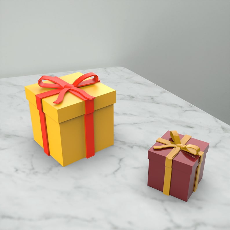 May include: Two gift boxes, one yellow with a red ribbon and one burgundy with a gold ribbon, on a white marble surface.
