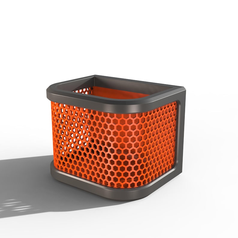 May include: A modern orange wastebasket with a honeycomb pattern. The wastebasket has a dark gray frame and base, and a rectangular shape. The interior is also orange. The design is sleek and contemporary.
