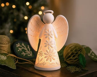 May include: A white ceramic angel figurine with a halo and detailed wings. The angel's dress is adorned with daisy cutouts that illuminate when lit. The figurine is approximately 15 cm tall, perfect for holiday decor.